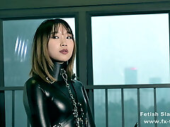 Bondage leather catsuit girl on single gloves