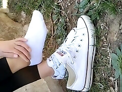 Asian girl sprains foot in white ankle socks and black leggings