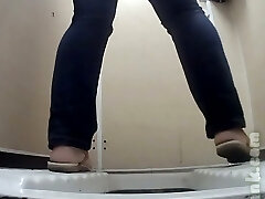 botín de piel pálida de una extraña en jeans filmada desnuda en el baño