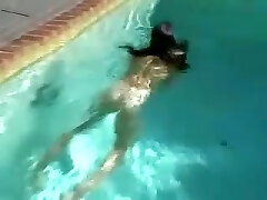 une adolescente brune douce et sexy en bikini noir se déshabille et se masturbe au bord de la piscine