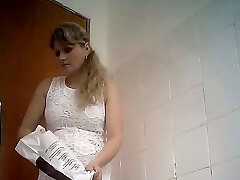 细曲线优美的金发女郎在白色礼服拍摄的厕所房间