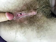 Hairy girl ravages her raw big clit pussy with dildo in close up