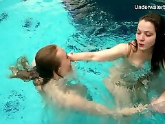 dos hermosas chicas están desnudas mientras nadan juntas bajo el agua
