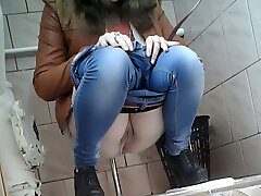 Slender girl in very taut blue jeans filmed in the rest room room