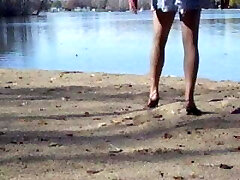 Crossdresser en el lago en la manguera y tacones