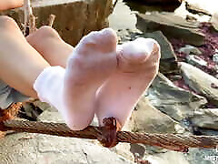 Goddess feet in dirty white urdu oudio closeup against sea sunset