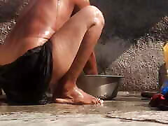 The stepsister is bathing naked in an open bathroom in the village