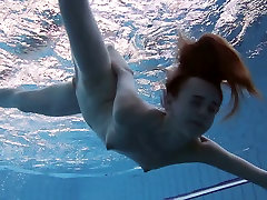 Szczupła ruda dziewczyna Anna Netrebko pływa nago pod wodą