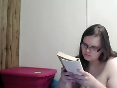 Nerdy pregnant girl reading naked in bed