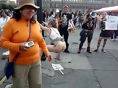 hembra agitador se hace pis y caca en un cartel en una manifestación en protesta contra el gobierno