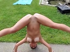 Naughty nudist does a headstand for the crowd