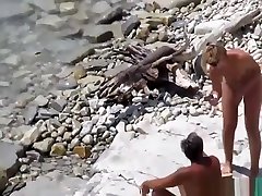 Older nudist couple enjoying the shallow waters