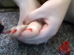 painting toes red while naked