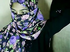 हिजाब पहने लड़की उंगलियों बिल्ली