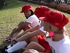 Three Girls In Short Red Skirt In A Garden