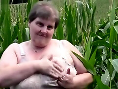 Old, fat grandma in a cornfield masturbating with huge dildo.