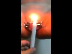 Women playing with candle inside pussy