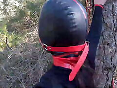 Tied up to a tree, outdoors in mom get interactial clothes, ball gagged