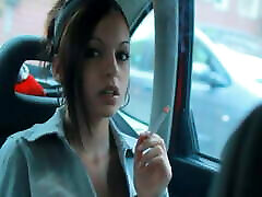 dame raucht im auto mit geöffneten fenstern