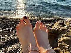 pani lara bawi się nogami i palcami na plaży