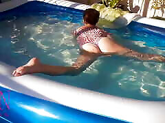 सुरुचिपूर्ण और लचीली बेब, आउटडोर स्विमिंग पूल little guy with women पानी के नीचे तैरना । स्विमिंगसुइट