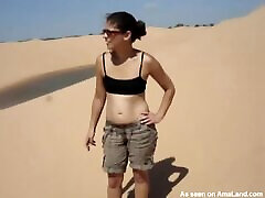 Naughty brunette chick flashing her maphone model in desert