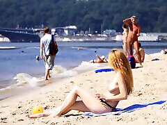 Nude beach girl is having a great time as she spreads her legs