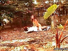 Asian cute litter is fucked in the garden on some papers