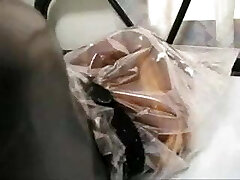 Girl in Rubber with Bag on Head and Vibrator