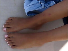 Young gal's footplay on the beach