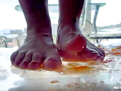 Squeezing cherry tomatoes with bare feet POV on your face