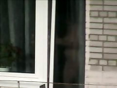 裸体的成熟的女人抓住了从卧室窗口的一个偷窥