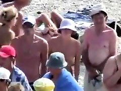 нудистский пляж-наклониться над девушкой