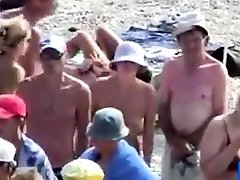 нудистский пляж-наклониться над девушкой