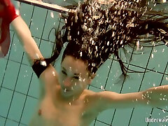 Adorable brunette teenie underwater flashes her shaved cooter